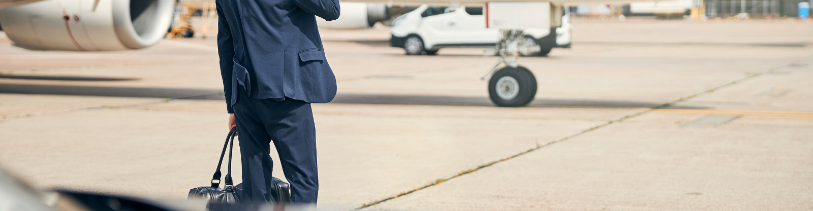 JetTarmac+Car_1600x900px_ManBusinessonthephone businessman on important phone call on tarmac in front of private jet