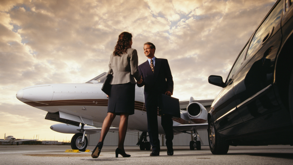 business man and business woman on tarmac entering a private jet