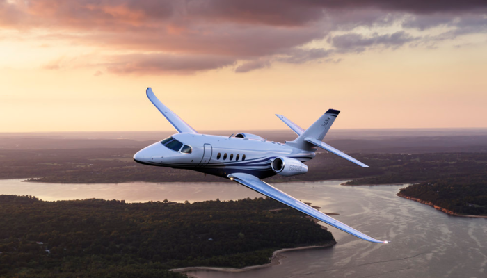 Midsize jet Cessna Citation Latitude Flying over River