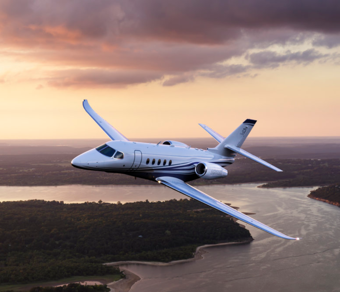 Midsize jet Cessna Citation Latitude Flying over River