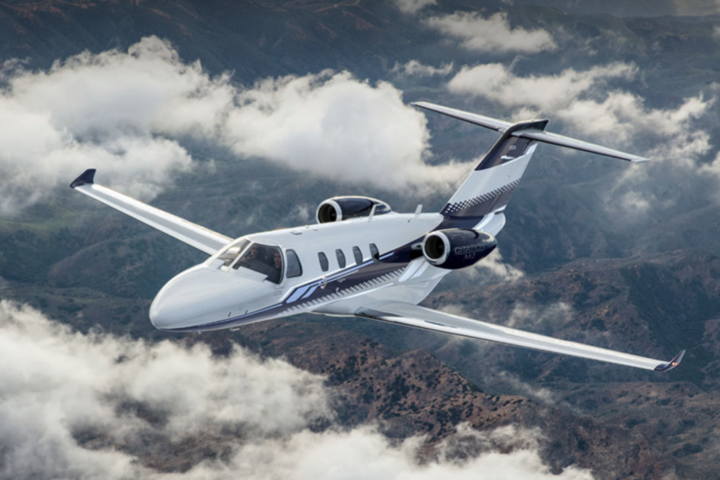luxurious very light jet flying in front of clouds