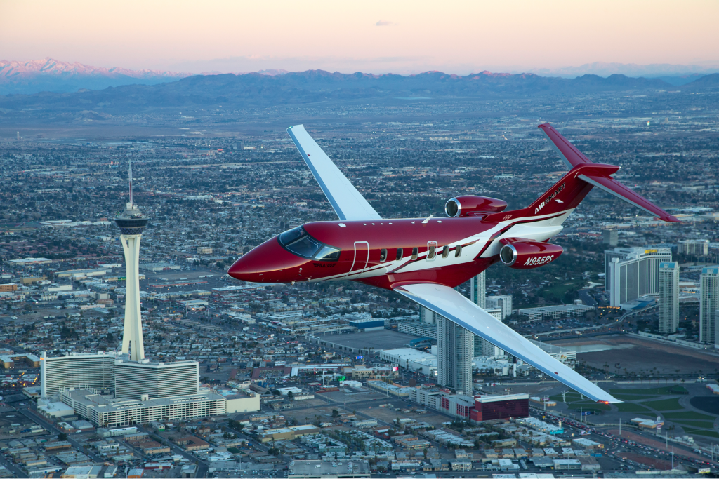 private jet flying over vegas strip at dusk