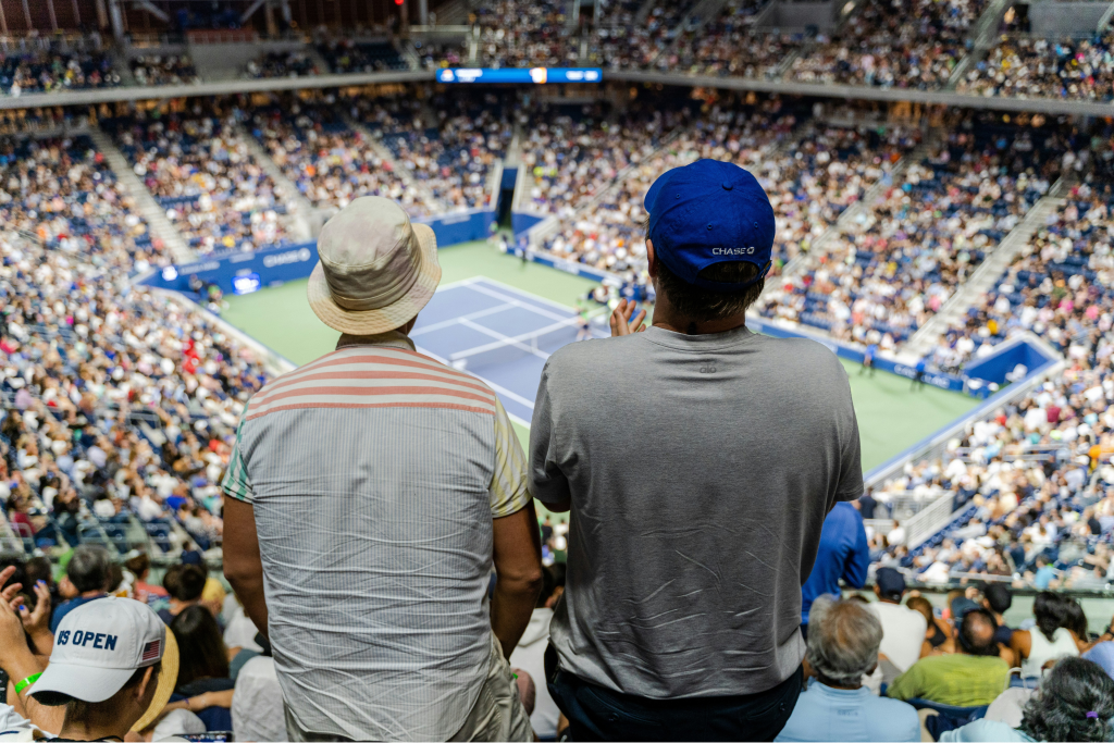 Two fans stand to cheer on tennis action during the 2022 US Open in New York City