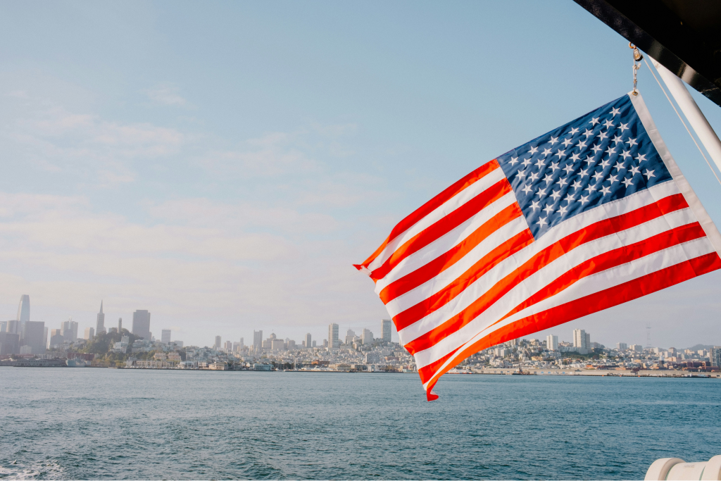 american flag flying over water in san fran sisco