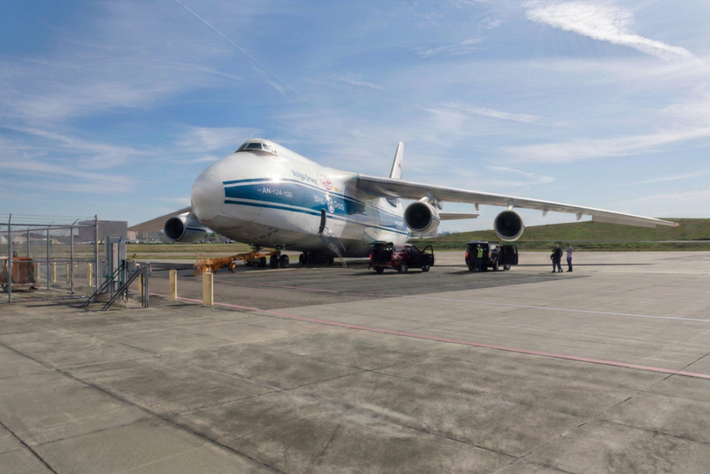 cargo jet on runway with people loading the jet